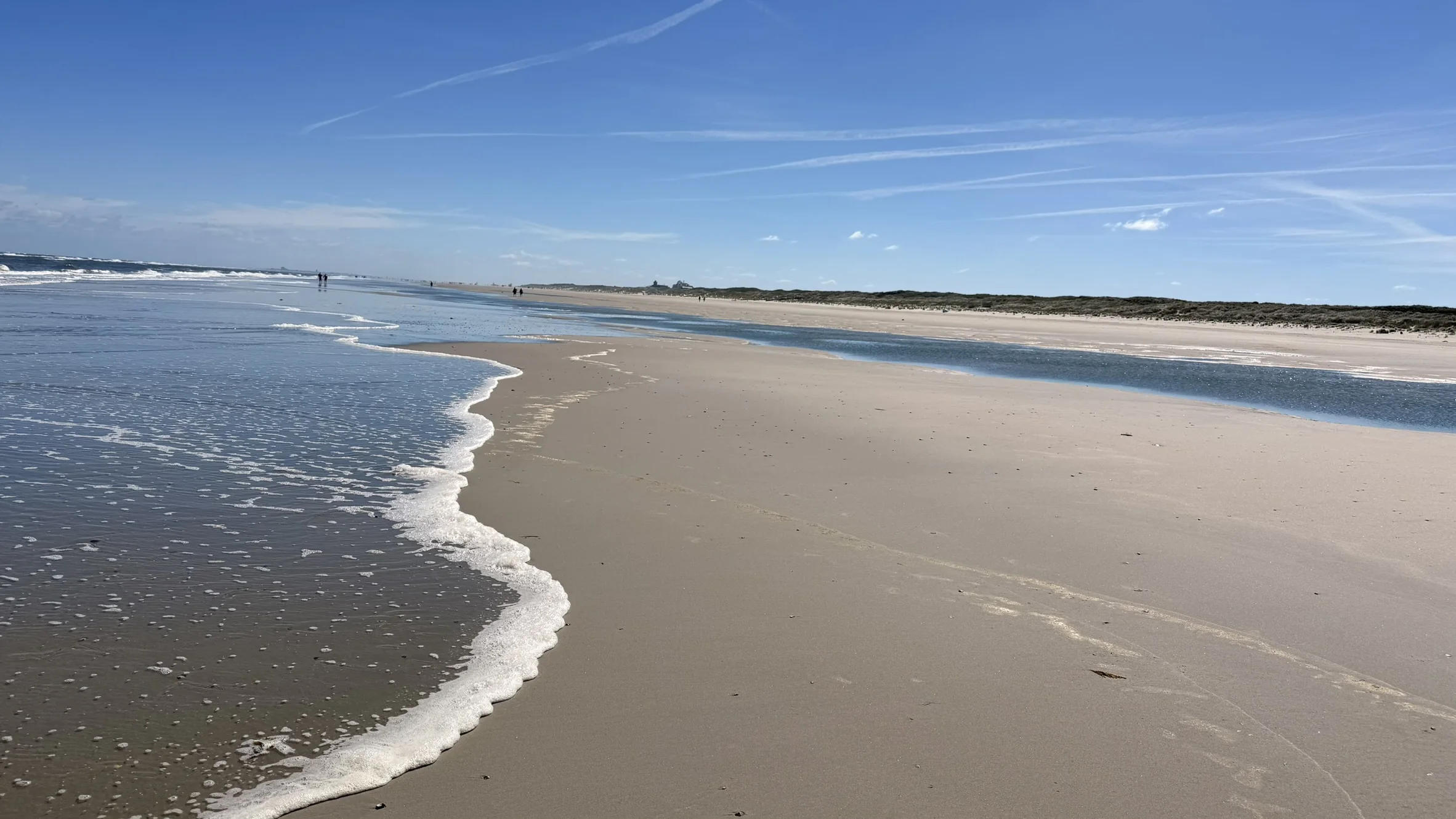 Weite Wasserkante an einem sonnigen Nordseestrand