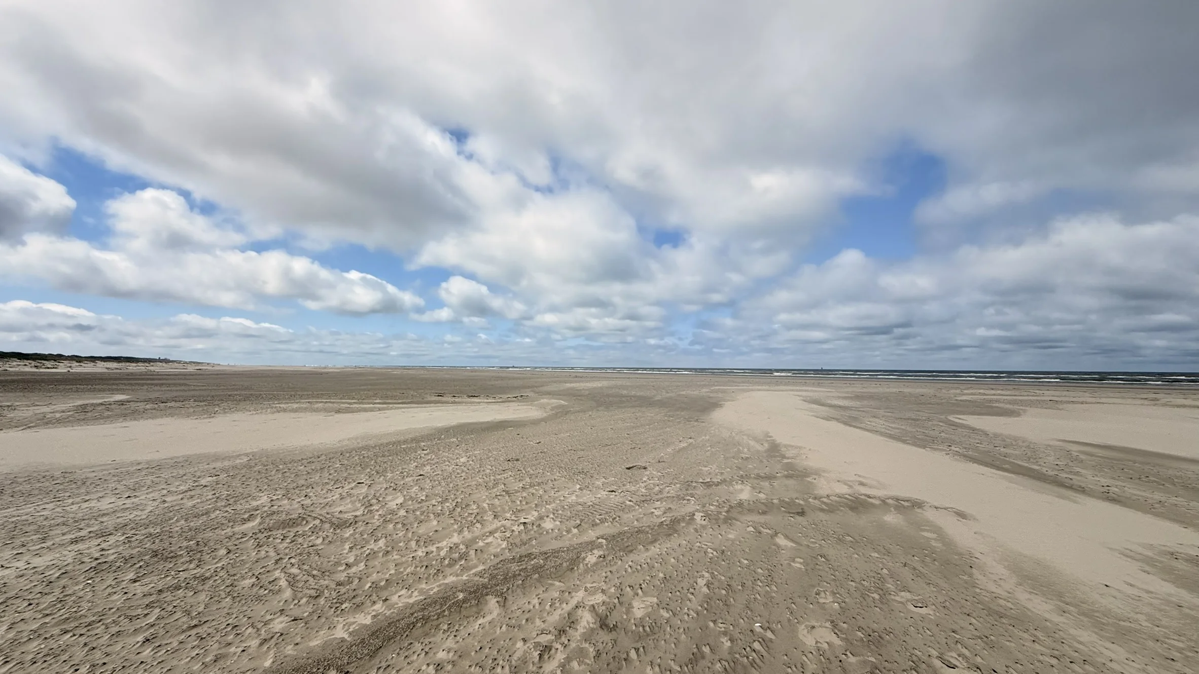 Breiter Strand unter großen Wolken