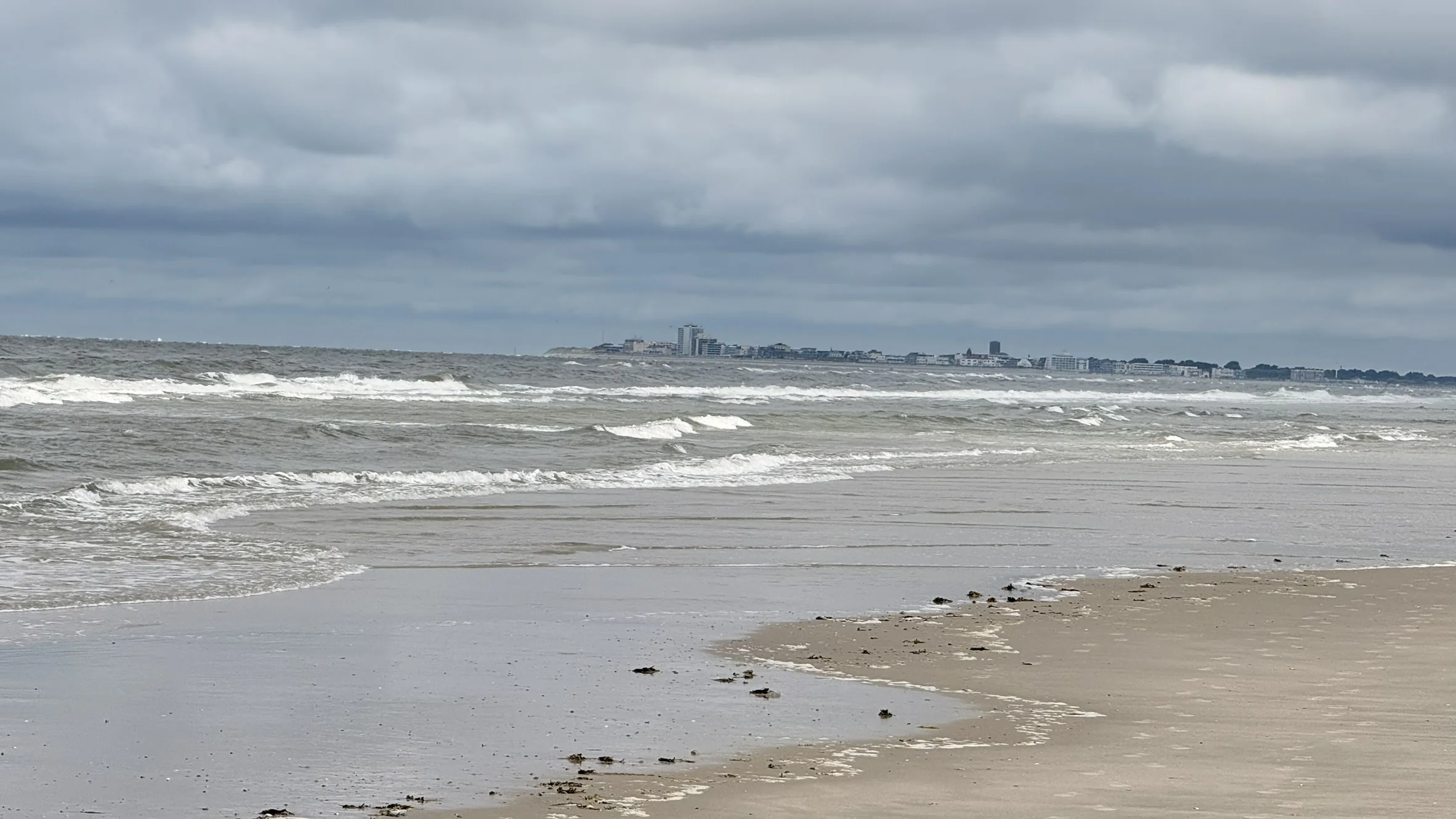 Blick über die Brandung zur fernen Küste