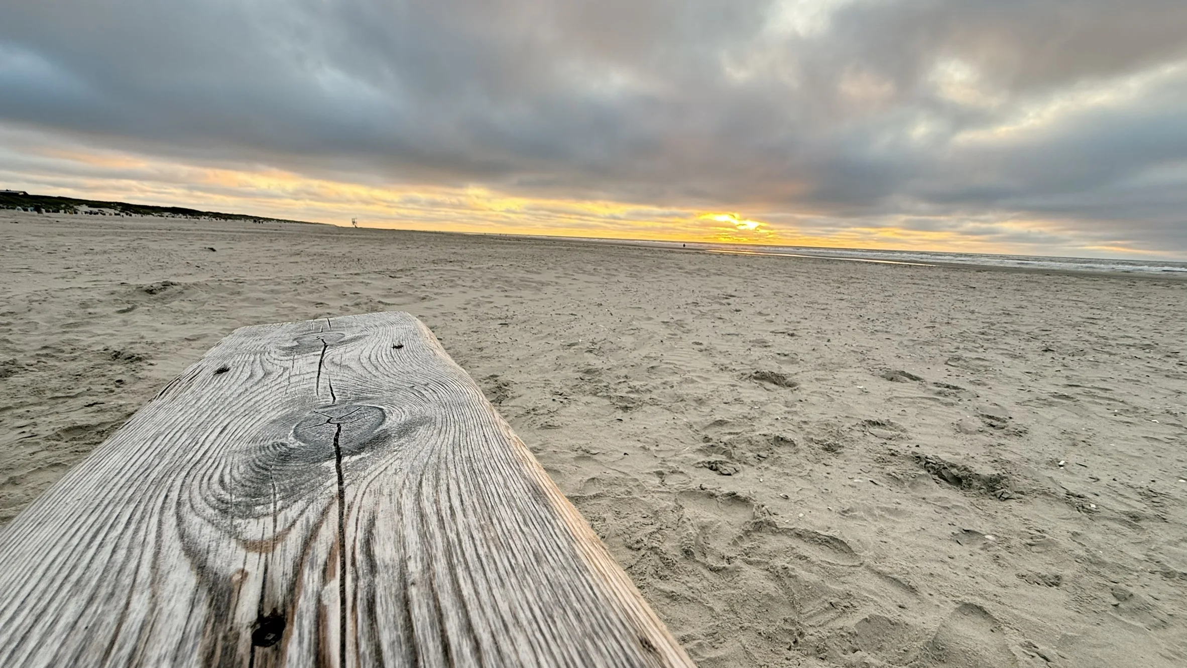 Holzbank am Strand vor dem Sonnenuntergang